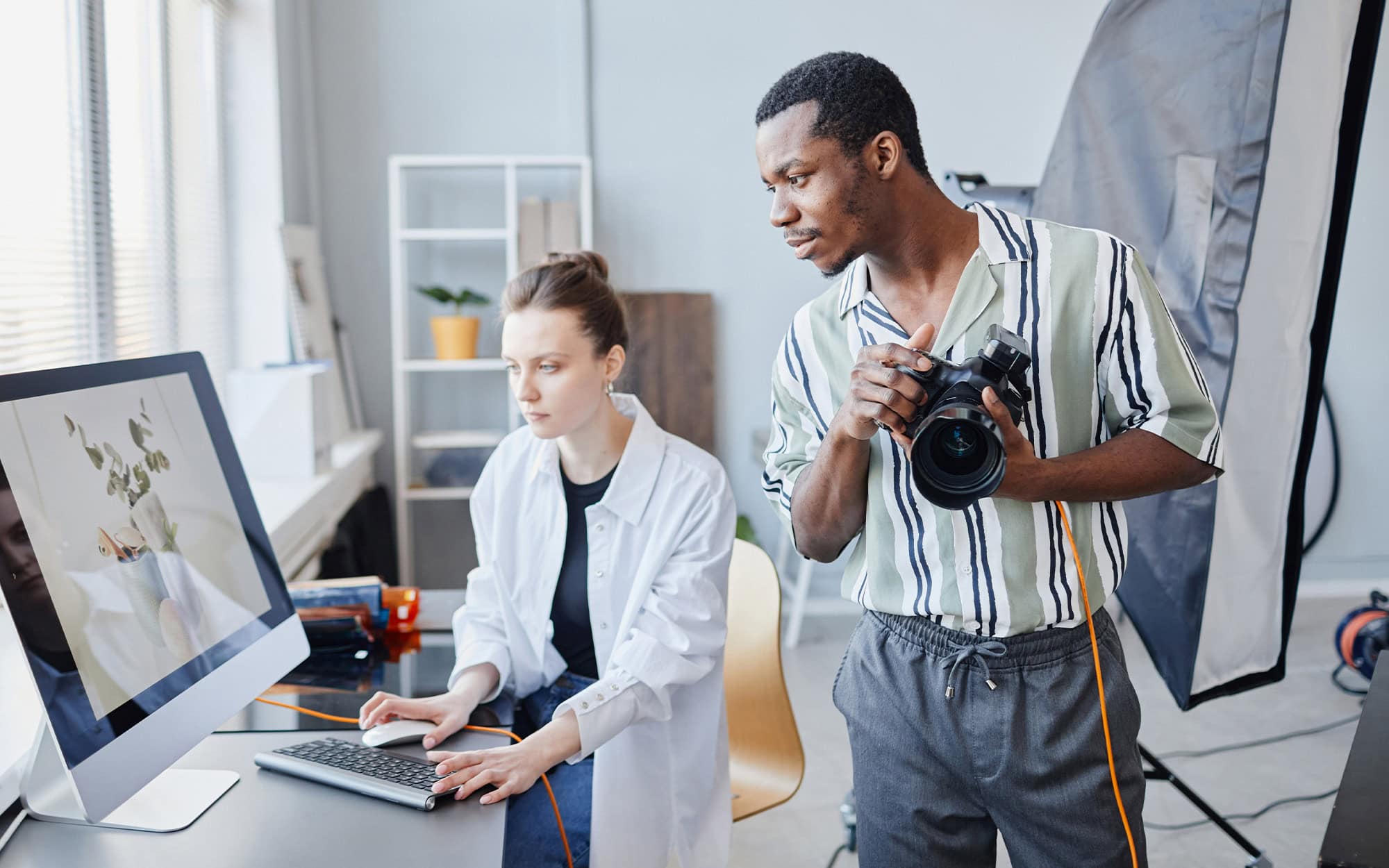 Minimal Portrait Of Two Photographers Working As Team On Product Photoshoot In Studio