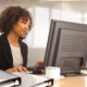 Young Businesswoman Using Computer At Desk Indoors Office Building
