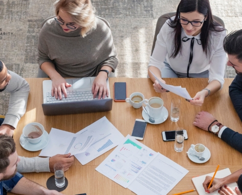 Nonprofit staff collaborating around a table, representing shared leadership and organizational resilience beyond any single founder